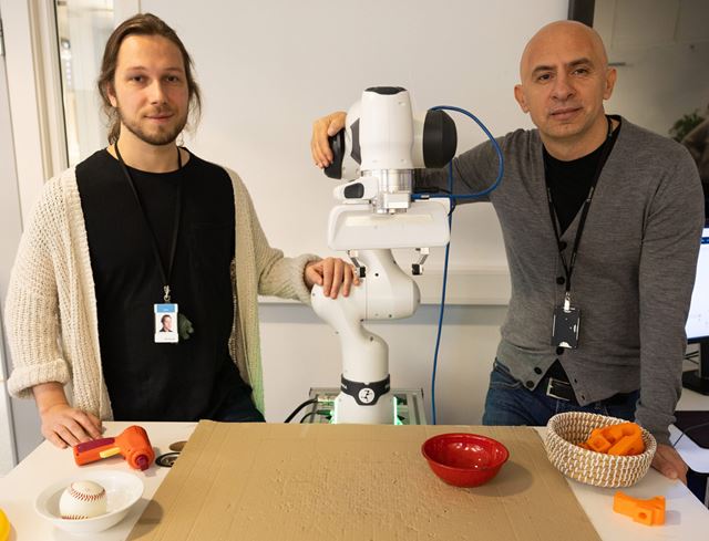 PhD-student Sverre Herland og seniorforsker Ekrem Misimi med roboten i laben. Foto: SINTEF